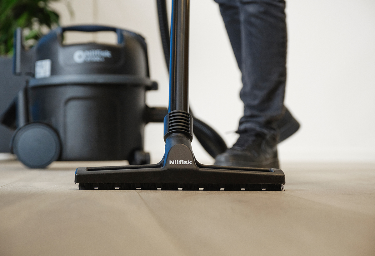 Εδώ απεικονίζεται σε πολύ κοντινή όψη η σκούπα να καθαρίζει ένα ξύλινο πάτωμα.